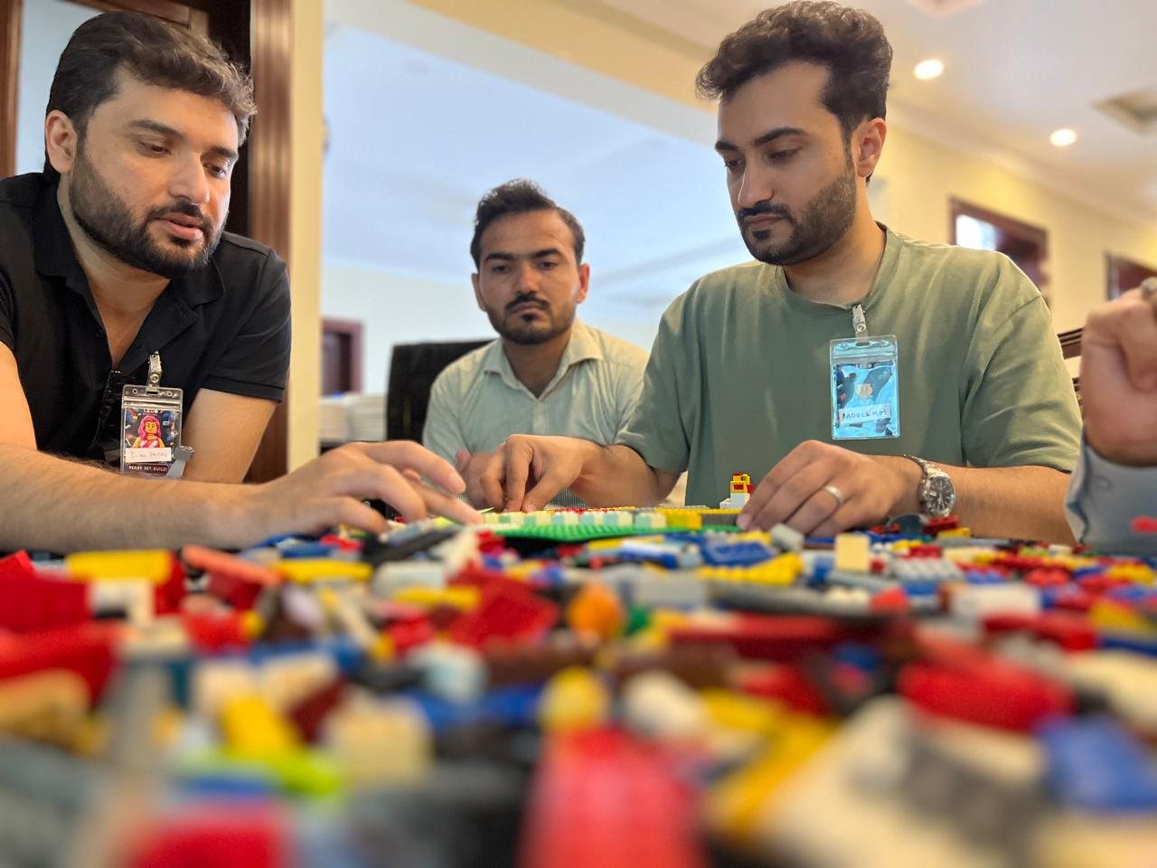 Zindigi team members gathered around their LEGO builds, taking turns to share the story behind each model