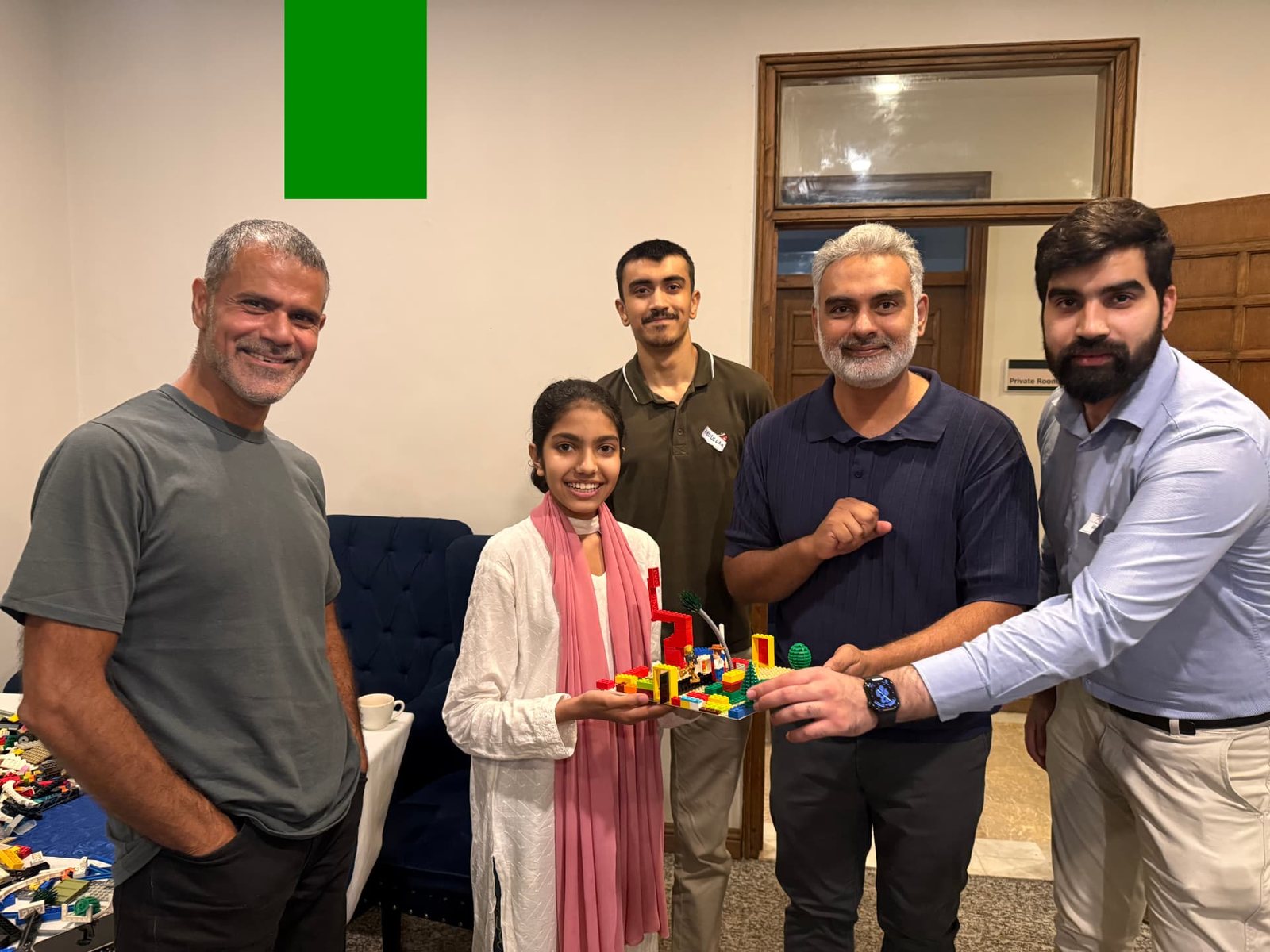 The AdVentures Academy team holding up a joint LEGO build during their internal LEGO AdVentures session facilitated by Syed Sajid Ali