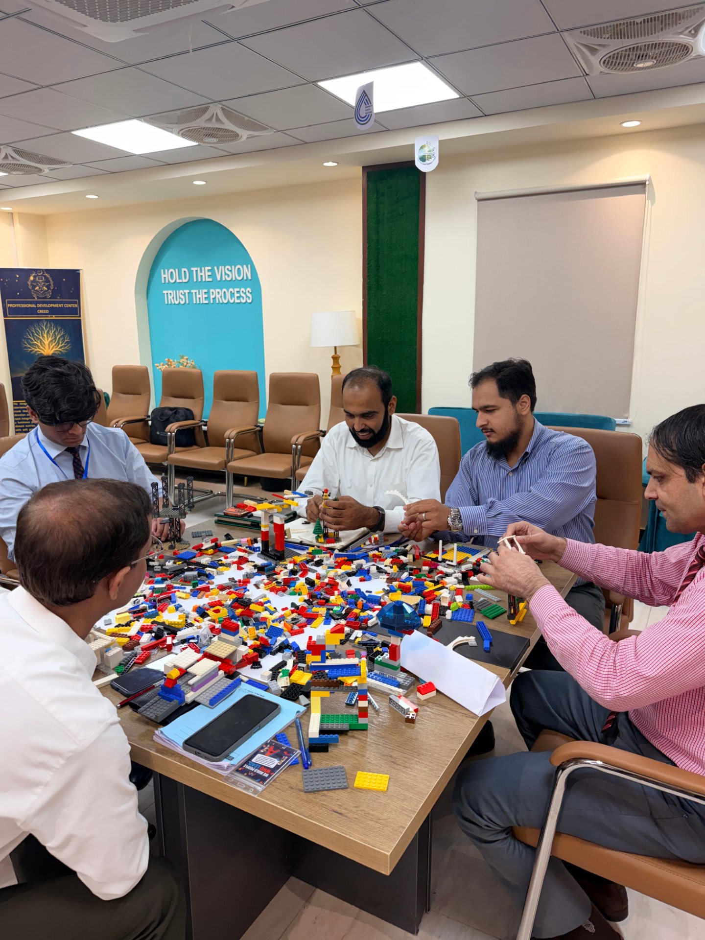 Fauji Foundation participants collaborating on a shared LEGO landscape during an AdVentures Academy session